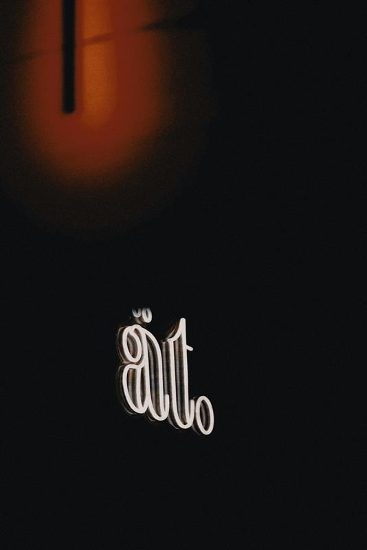Restaurang ät:s logotyp på en ljusskylt