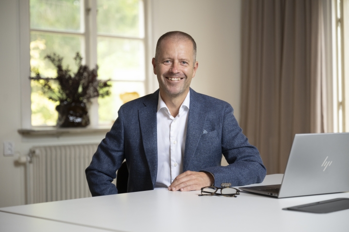 Dieter Sand, vd Arlandastad Group, sittande vid ett bord.
