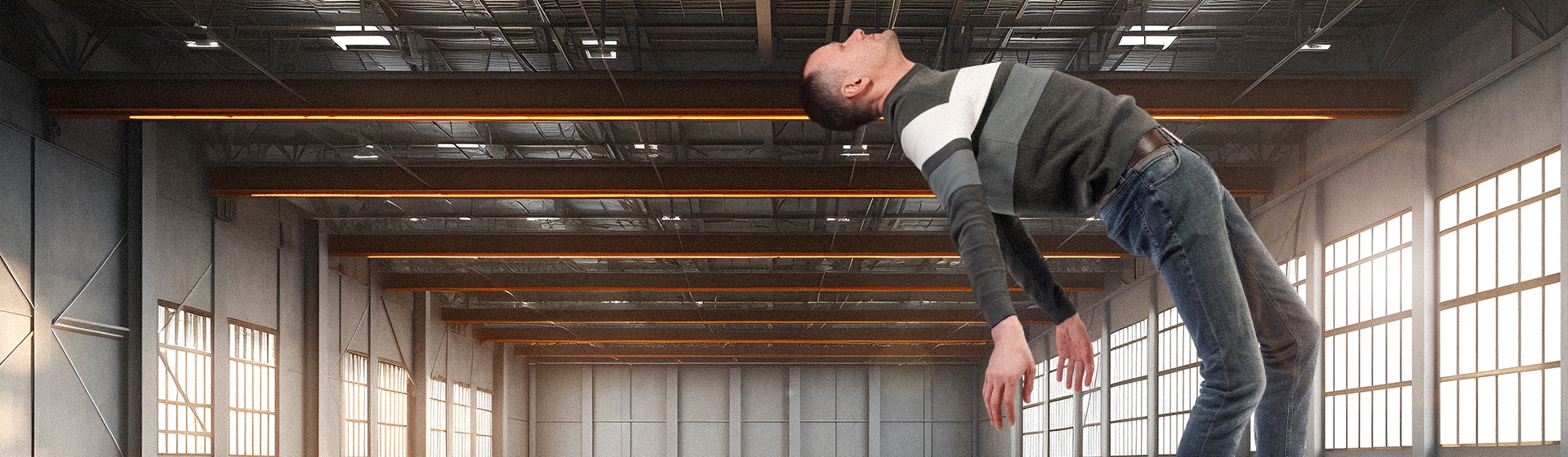 En man i grå kläder som lyfter från golvet i en hangar